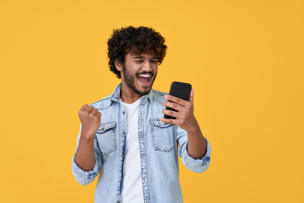 man cheering on his phone